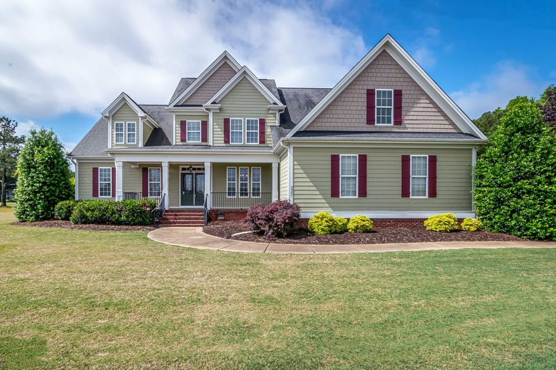 A two-storey family house with a porch and a front lawn.