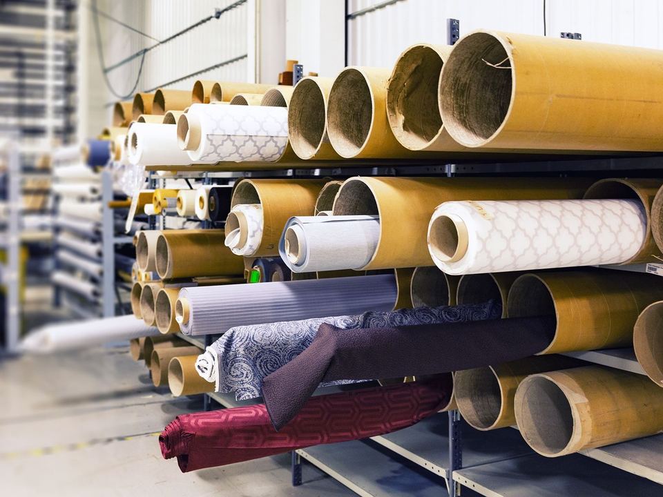 Rows of fabric rolls stored in a textile factory.