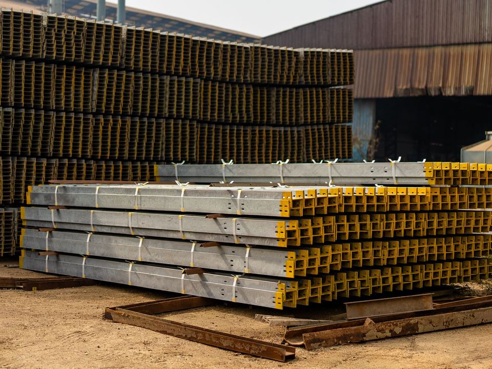 Stacks of steel beams in an industrial yard.