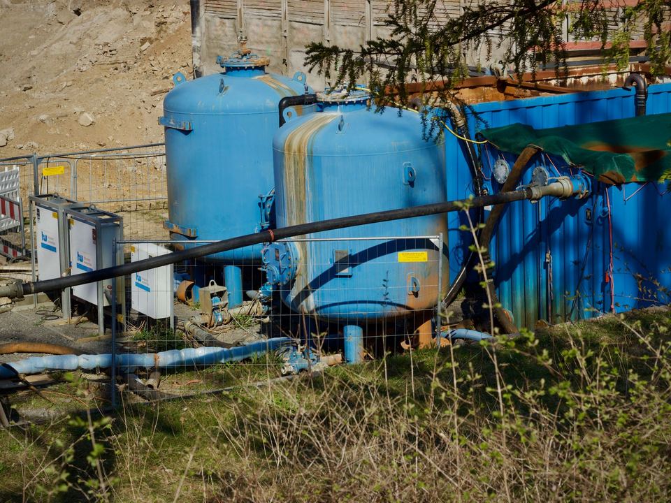 Large blue water tanks at an outdoor filtration plant.